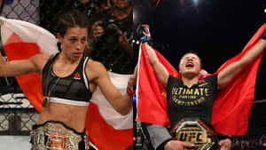 兩名女性MMA冠軍在八角籠中手持旗幟和腰帶慶祝勝利。 — 拼貼 壁紙