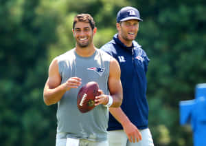 兩名身穿愛國者隊裝備的美式足球員在戶外訓練時微笑。 — NFL 美式足球 壁紙