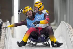 兩名雪橇運動員在奧運期間於冰道上慶祝勝利。 — 奧運 壁紙