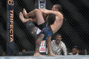 兩名MMA拳手在UFC八角籠內進行纏鬥。 — 3:2 壁紙