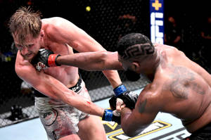 兩名男性MMA拳手在血跡斑斑的八角籠比賽中交換強力打擊。 — 終極格鬥冠軍賽 壁紙