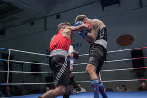 兩名男性拳擊手在擂台上於比賽中互相出拳。 — 運動 壁紙