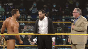 WWE NXT摔角手和評論員在擂台上，觀眾戴著面具。 — 摔角 壁紙