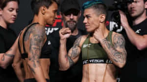 兩名女性MMA拳手帶著刺青和UFC裝備在比賽前互相凝視。 — 終極格鬥冠軍賽 壁紙