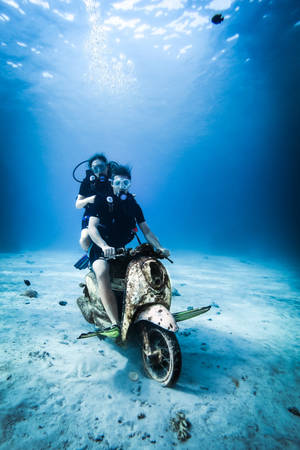 兩名水肺潛水員在海床上騎著一輛潛水摩托車。 — 水肺潛水 壁紙