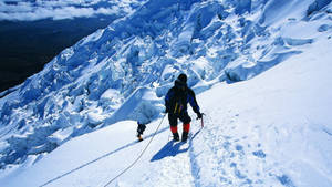 兩名登山者用繩索相連，攀登積雪的冰川斜坡。 — 攀爬 壁紙