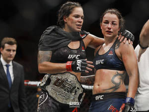 兩名女性MMA拳手在血腥的UFC比賽後擁抱，其中一人手持冠軍腰帶。 — 終極格鬥冠軍賽 壁紙