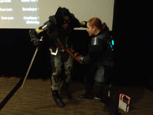 兩名科幻cosplay的人在舞台上用劍戰鬥。 — 恐怖反派 壁紙