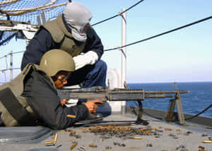 水手在軍艦甲板上發射重型機槍，背景為海洋。