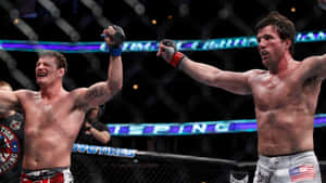 兩名汗流浹背的MMA拳手在八角籠內高舉雙臂慶祝勝利。 — 運動 壁紙