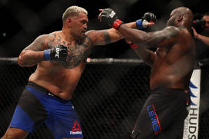 兩名MMA拳手在UFC比賽期間於八角籠中互相出拳。 — 終極格鬥冠軍賽 壁紙