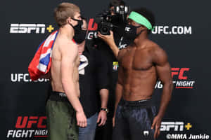 兩名戴著口罩的MMA拳手在UFC稱重活動中面對面站立。 — 運動 壁紙