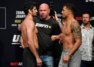 兩名男性MMA拳手在UFC稱重活動中與裁判和攝影團隊互相凝視。 — 運動 壁紙