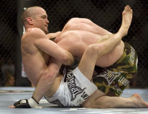 兩名男性MMA拳手在八角形內的藍色墊子上鎖定纏抱姿勢。 — 終極格鬥冠軍賽 壁紙