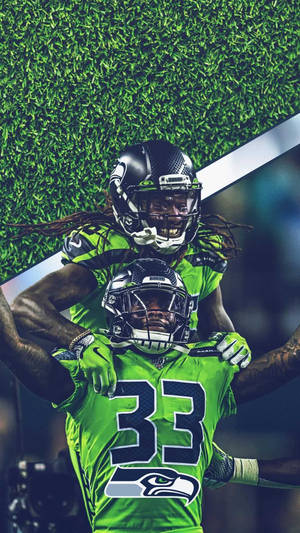 兩名海鷹隊球員在草地上穿著綠色球衣慶祝。 — Dk Metcalf 壁紙