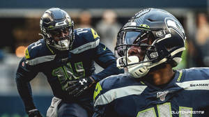 兩名海鷹隊美式足球員在比賽中全神貫注地奔跑。 — Dk Metcalf 壁紙