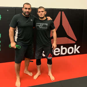 兩名身穿Reebok裝備的男性拳手在紅色健身墊上擺姿勢。 — 終極格鬥冠軍賽 壁紙