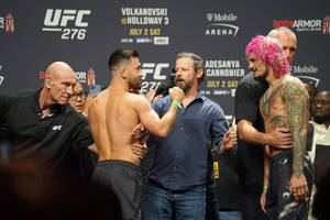 兩名UFC拳手在稱重活動中以粉紅色頭髮和紋身互相對峙。 — 終極格鬥冠軍賽 壁紙