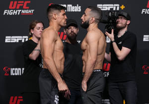 兩名男性UFC拳手在媒體和工作人員在場的稱重活動中對峙。 — 終極格鬥冠軍賽 壁紙