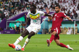 兩名足球運動員在夜間比賽中爭奪控球權。 — FIFA 世界盃 壁紙