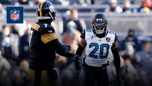 兩名NFL美式足球員在日間比賽中於場上握手。