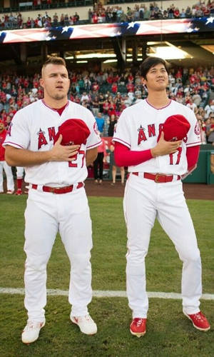 兩名身穿天使隊球衣的棒球運動員在球場上將帽子放在心口。 — Mike Trout 壁紙