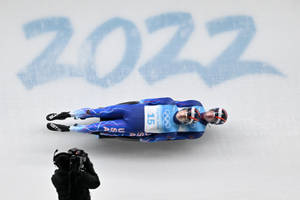2022年冬奧會期間，兩名雪橇運動員在冰道上競速。 — 運動風 壁紙