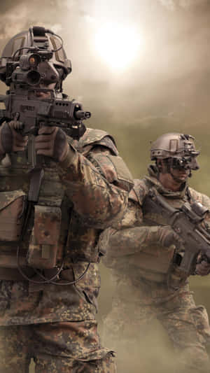 兩名身穿迷彩裝備的武裝士兵穿越塵土飛揚的地形。 — 美國陸軍 GIF 壁紙