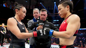 兩名女子MMA拳手在場館燈光下於UFC比賽前碰拳套。 — 運動 壁紙