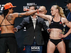 兩名女子MMA拳手在稱重活動中鎖拳。 — 終極格鬥冠軍賽 壁紙