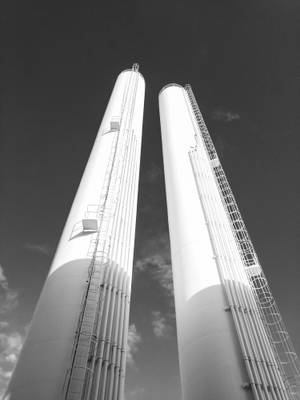 兩座帶有梯子的高大白色工業煙囪，背景是多雲的天空。 — 里約熱內盧 壁紙