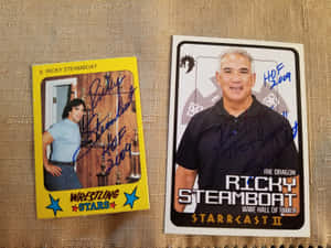 兩張簽名的Ricky Steamboat摔角交換卡在米色布料背景上。 — 冠軍 壁紙