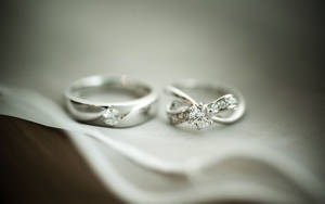 白色布料上的兩枚鑽石結婚戒指 — 婚禮 壁紙
