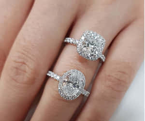 女士手上的兩枚鑽石訂婚戒指，閃爍著璀璨光芒。 — 結婚戒指 壁紙
