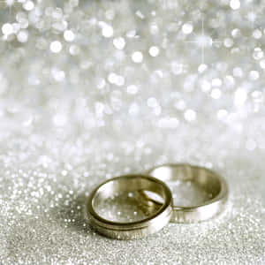 兩枚銀色結婚戒指在閃閃發光的銀色背景上。 — 結婚戒指 壁紙