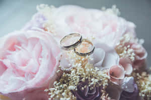 兩枚結婚戒指藏在粉紅和薰衣草花束中。 — 結婚戒指 壁紙