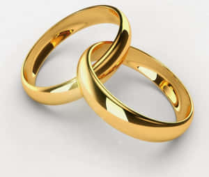 兩枚金色結婚戒指在白色背景上交織。 — 金色動態 壁紙