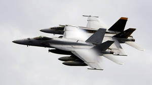 兩架戰鬥機在陰天編隊飛行，留下蒸汽痕跡。 — 軍事動圖 壁紙