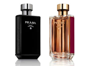 兩瓶Prada Milano香水，一瓶黑色，一瓶琥珀色帶酒紅色條紋，白色背景。 — Prada 壁紙