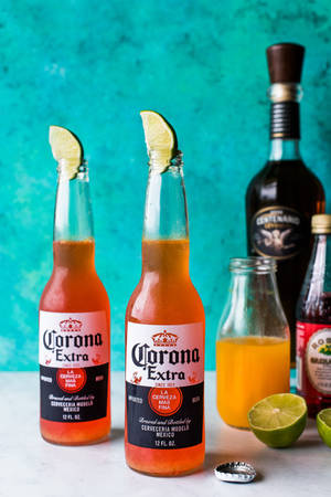 兩瓶Corona啤酒連同萊姆角和龍舌蘭酒瓶放在白色表面上。 — 啤酒 壁紙