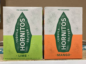 兩盒Hornitos龍舌蘭酒蘇打水青檸和芒果口味在檯面上。 — 品牌 壁紙