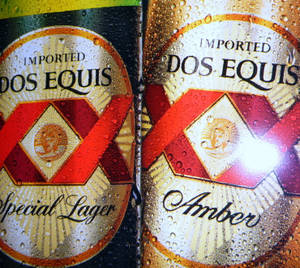 兩罐冰冷的Dos Equis啤酒罐，標籤上有水珠。 — 啤酒 壁紙