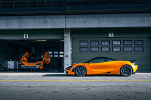 車庫中的兩輛橙色McLaren超級跑車，其中一輛車門打開 — 4K 法拉利 壁紙