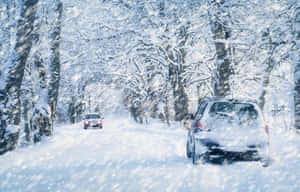暴風雪中，兩輛汽車在白雪覆蓋的森林道路上行駛。 — 冬季風景 壁紙