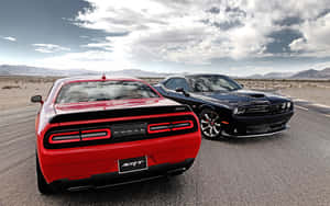 兩輛Dodge Challenger SRT肌肉車停放在沙漠公路上，背景有山脈。 — 道奇挑戰者 壁紙