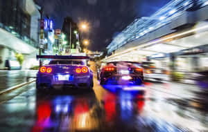 兩輛跑車在夜間雨中的城市裡疾馳，燈光閃爍。 — 街頭 壁紙