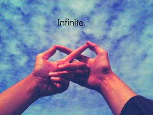 兩隻手在藍天下形成一個無限標誌，並帶有「infinite」一詞。 — 無限符號 壁紙