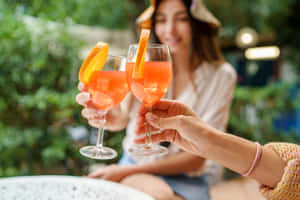 兩人在花園中以橙色雞尾酒乾杯 — 柳橙 壁紙