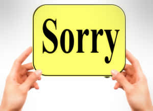 兩隻手拿著一個寫著 Sorry 的黃色牌子 — 手牽手 壁紙