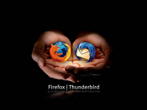 兩隻手捧著發光的 Firefox 和 Thunderbird 標誌。 — 桌面 壁紙